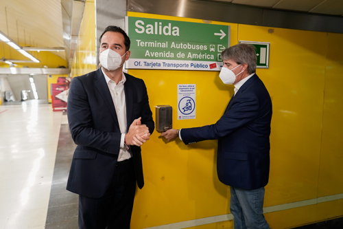 Ignacio Aguado, junto a Ángel Garrido, frente a un dispensador en la estación de Avenida de América