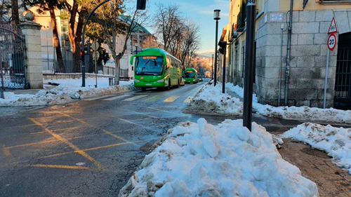 Autobús interurbano circulando por el interior de un municipio con nieve