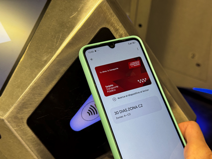 Detalle de un teléfono móvil con la tarjeta virtual cargada a su paso por una validadora